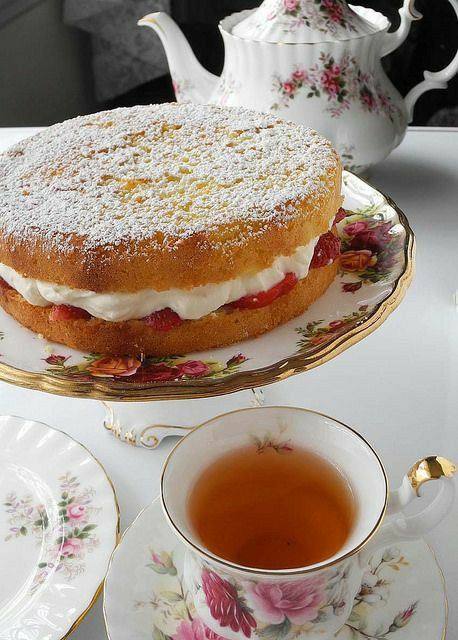 a cake sitting on top of a plate next to a tea cup and saucer