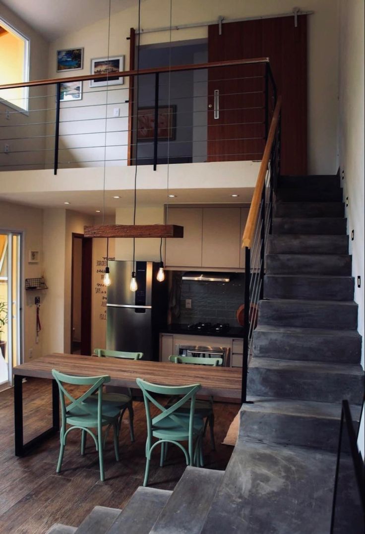 an open floor plan with stairs leading up to the kitchen and dining room area in this modern home