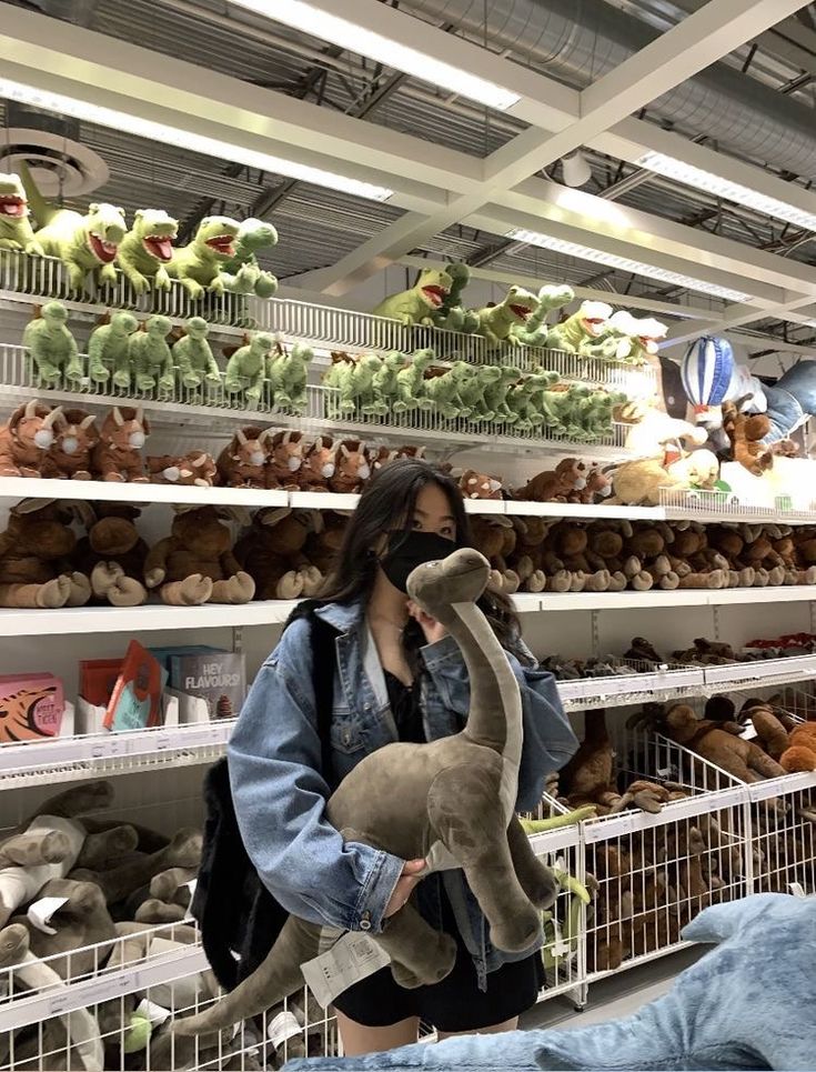 a woman is holding a stuffed animal in a store