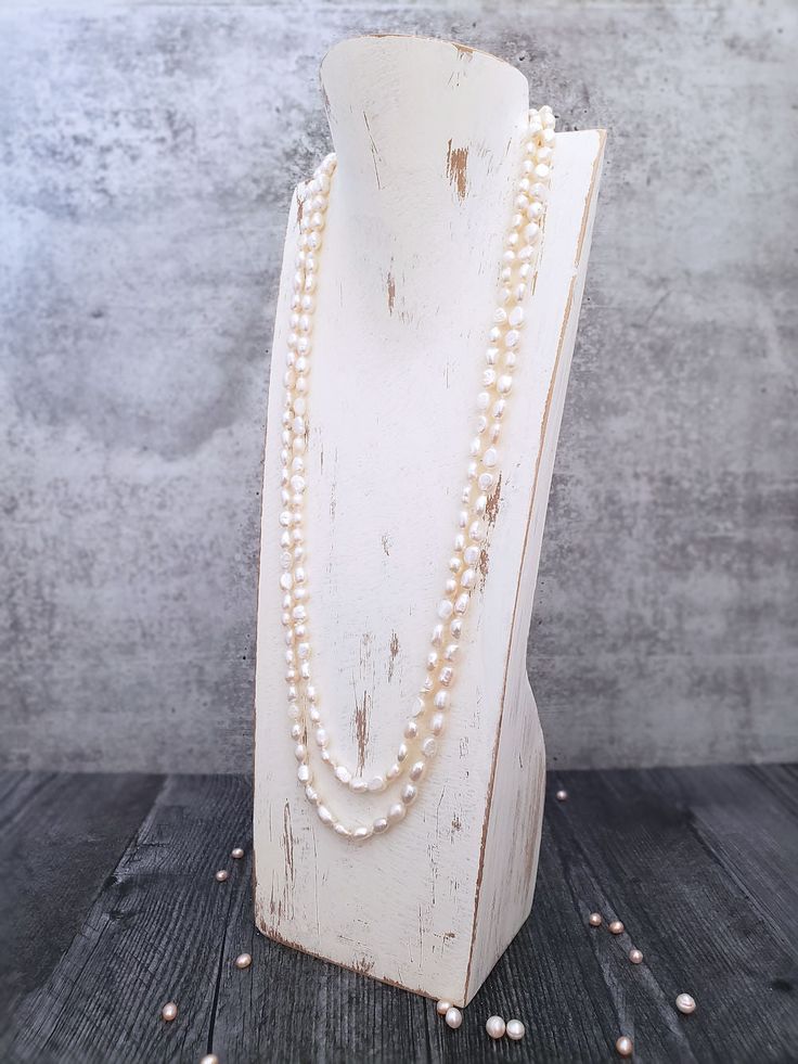 Ivory Pearl Necklace Shimmery and shiny semi-baroque pearls will charm you in this extra-long Ivory pearl necklace, which can be worn in an infinity of ways. The oval, semi-baroque pearls are hand-knotted onto a silk cord, a traditional way of showcasing pearls. Knotting makes necklaces stronger and also allows for a beautiful drape while at the same time protecting each pearl from rubbing up against the next. No worries about chasing beads around the floor with this necklace should it ever brea Ivory Pearl Necklace, Double Strand Necklace, Silk Cord, Ivory Pearl, Beautiful Drapes, Pearl Size, Strand Necklace, Baroque Pearls, Extra Long