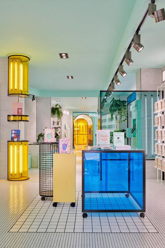 the inside of a store with blue and yellow glass cases on each side of the counter