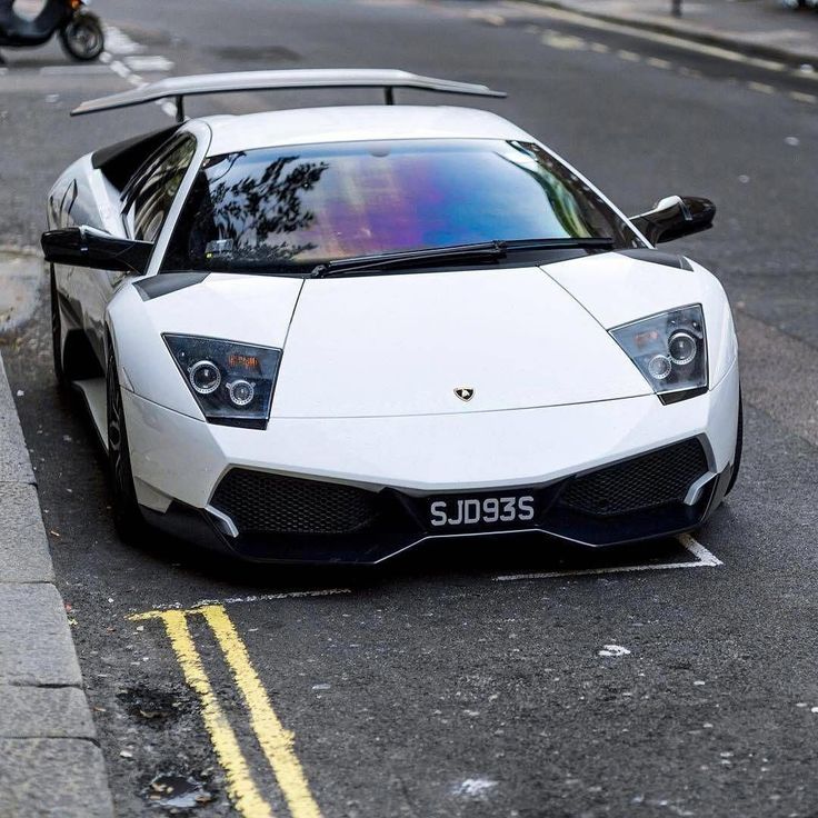 a white sports car is parked on the street