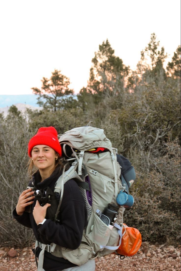 a woman with a backpack and camera in the wilderness