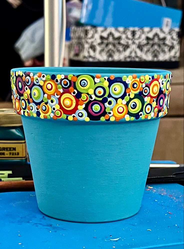 a blue flower pot sitting on top of a table