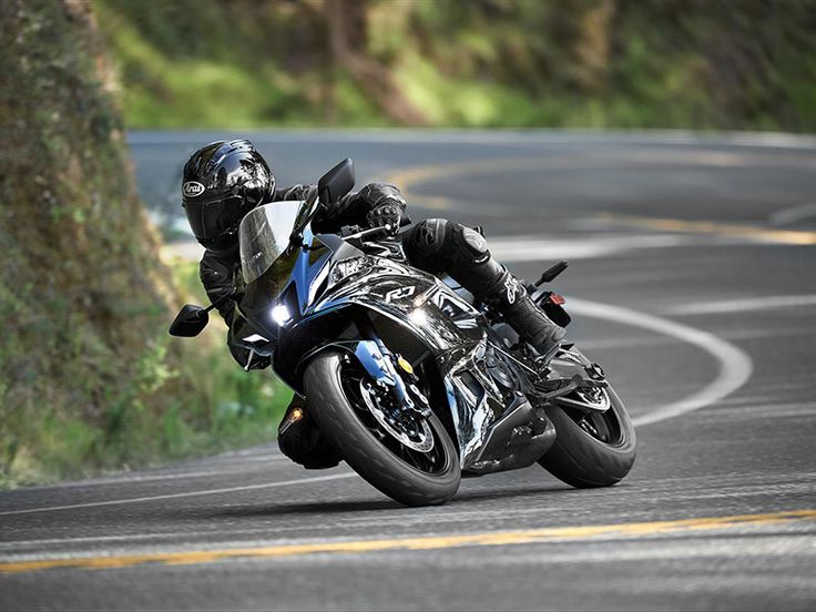 a man riding a motorcycle down a curvy road