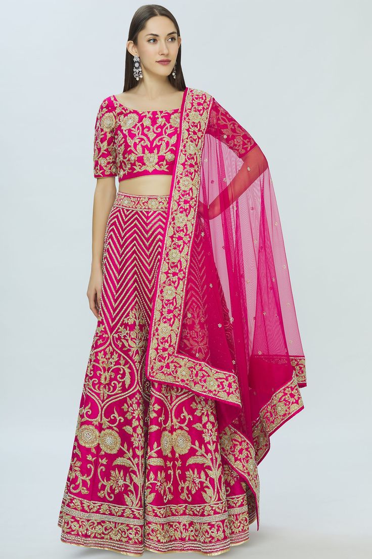 Fuschia floral embroidered lehenga paired with blouse and dupatta. 
Components:3
Embroidered
Neckline:Round
Sleeve Length:Elbow
Fabric:Dupion Raw Silk
Color:Pink
Back tassle tie-up blouse 
Embroidered floral lace border on dupatta
Closure:  
Lehenga: Side tassle detail  drawstring tie-up and side zip 
Blouse: Side zip - Aza Fashions Side Zip Blouse, Embroidered Bridal Lehenga, Embroidered Lehenga, Luxury Sale, Embroidered Neckline, Lace Border, Bridal Lehenga, Embroidered Silk, Embroidered Blouse