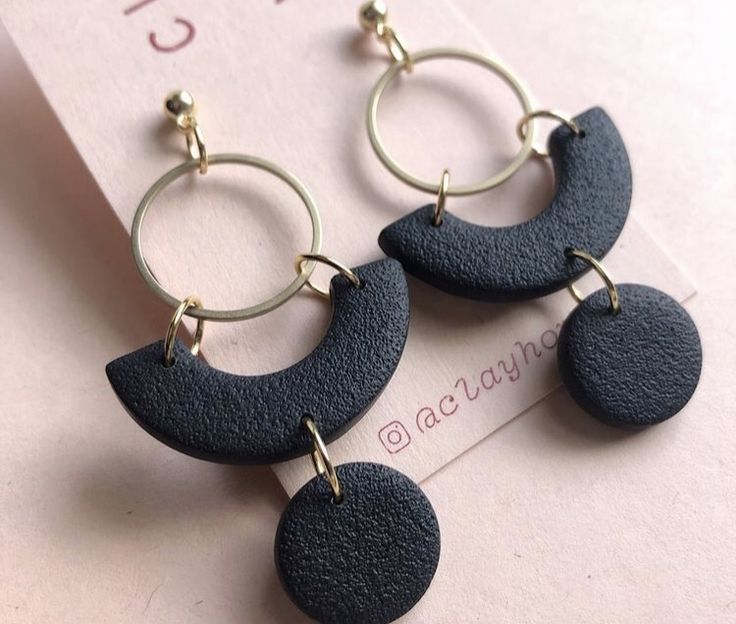 two pairs of earrings are shown on top of a piece of paper