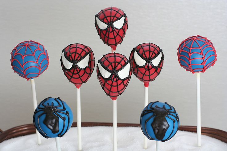 spiderman cake pops are sitting on top of the cake