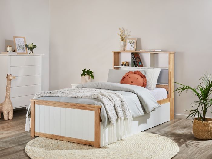 a bed with white linens and pillows in a small room next to a dresser