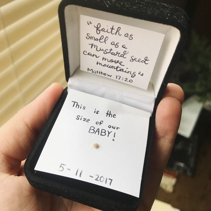 someone is holding up a tiny baby's birth card in their lapel box