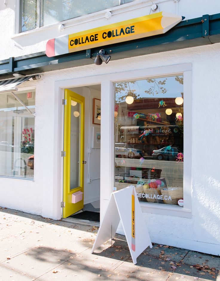 a store front with yellow door and window displays items for sale in the shop's windows