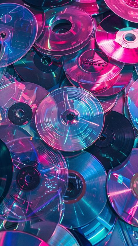 many different colored cds are stacked together in this photo, with one being pink and the other is blue