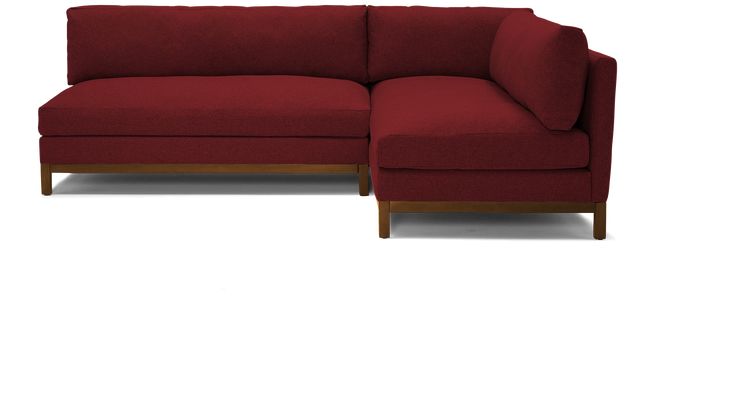 a red sectional couch sitting on top of a white floor next to a wooden frame