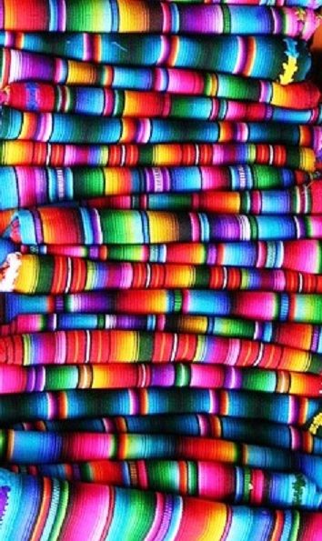 a large pile of multicolored cloths stacked on top of each other