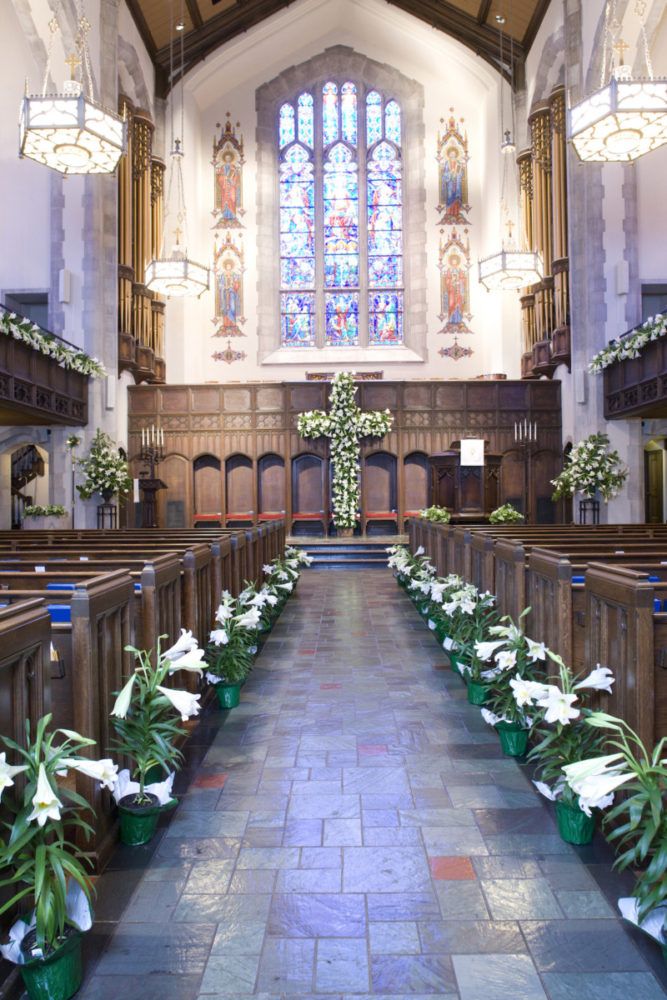 the inside of a church with pews and flowers