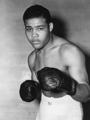 a black and white photo of a man wearing boxing gloves