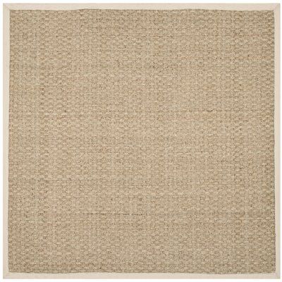 a beige rug with small squares on the bottom, and a white border around it