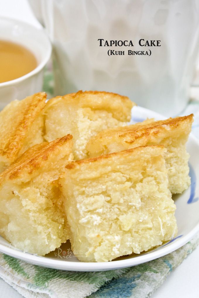 four pieces of cake on a plate next to a cup of tea and a napkin