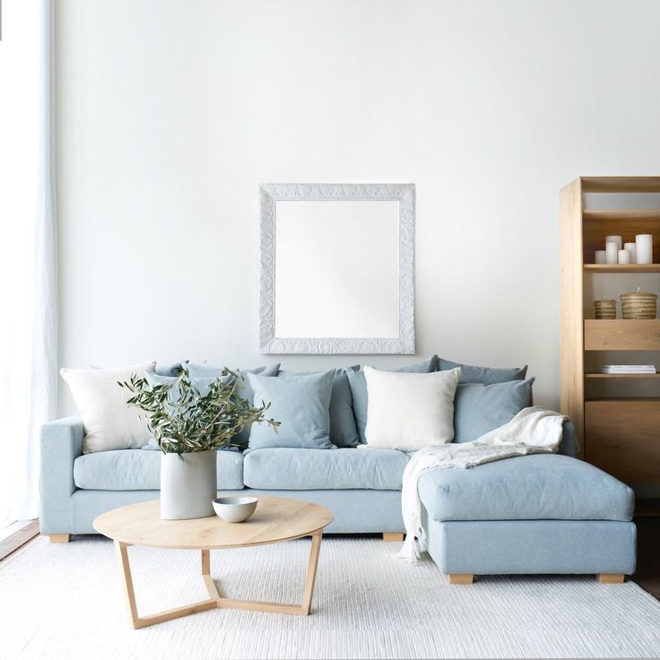 a living room filled with furniture and a large mirror on the wall above it's headboard