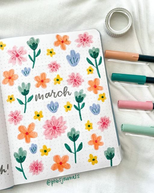 an open notebook with flowers and the word march written in cursive writing on it