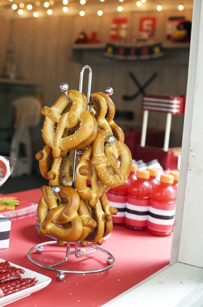 some pretzels are hanging on a stand in front of other food and drinks