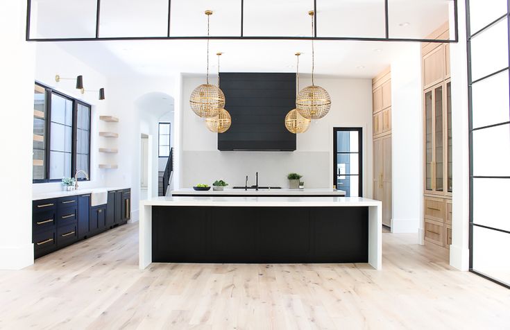 an open kitchen with black cabinets and white counter tops