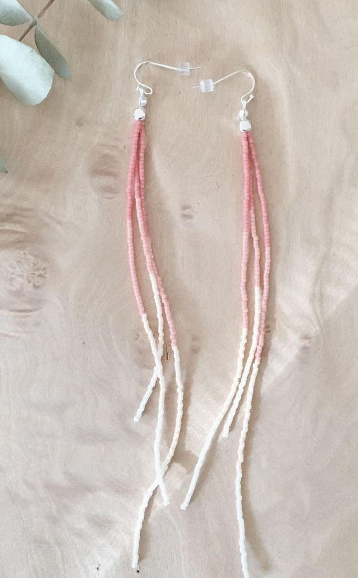 two strands of pink and white beads hanging from silver earwires