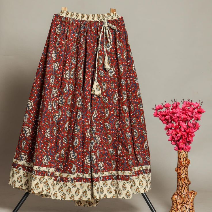 "Discover the enchanting allure of our Women's Hand Block Printed Long Skirt, meticulously crafted in the vibrant city of Jaipur, Rajasthan. This exquisite piece showcases the timeless artistry of hand block printing, a traditional technique that imparts a unique and captivating character to the garment. 100% cotton   Natural dyed   Hand block printed   Made by artist   Skirt flair 5 mtr   Skirt length 39\" Fashioned from premium-quality cotton, this maxi flared skirt not only provides comfort b Indian Pattern Skirt, Traditional Floral Print Festive Bottoms, Bohemian Sharara With Printed Motifs, Traditional Tiered Sharara For Diwali, Red Bohemian Sharara For Festive Occasions, Festive Red Bohemian Sharara, Festive Bohemian Red Sharara, Red Cotton Long Skirt, Festive Bohemian Long Skirt