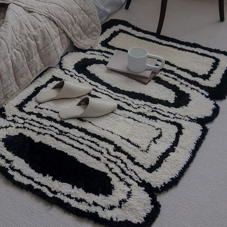 a bed room with a neatly made bed and two rugs on the floor next to each other