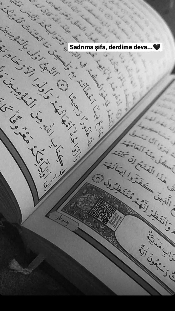 an open book with arabic writing on the pages and some words written in black ink