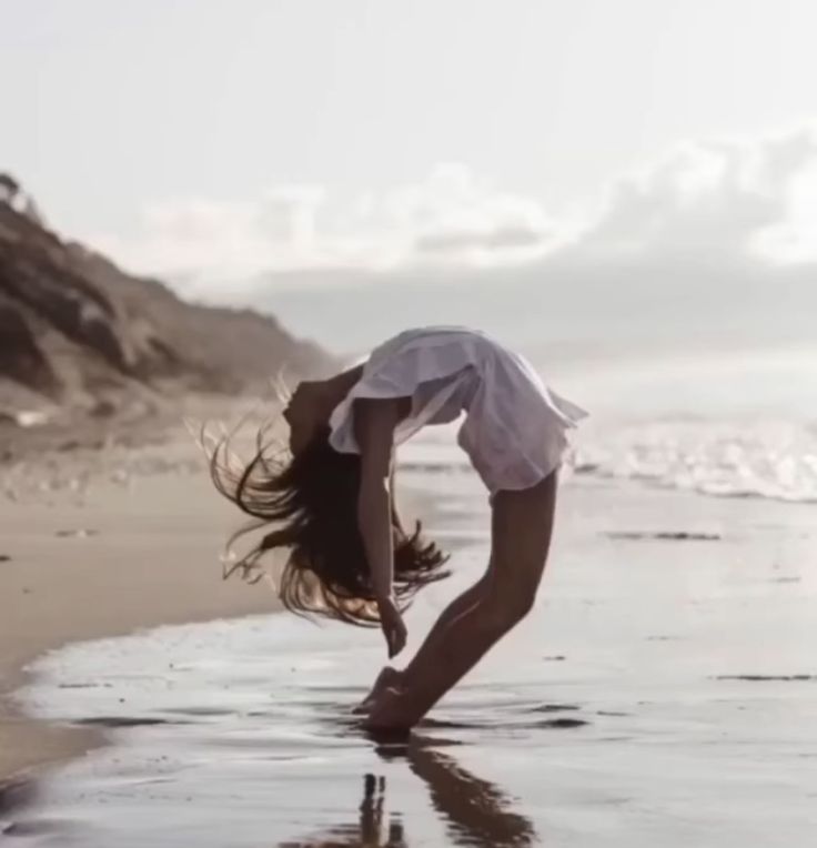 a woman standing on her head in the sand