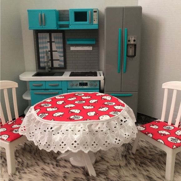 a doll house kitchen and dining area with table, chairs, refrigerator and stove top oven