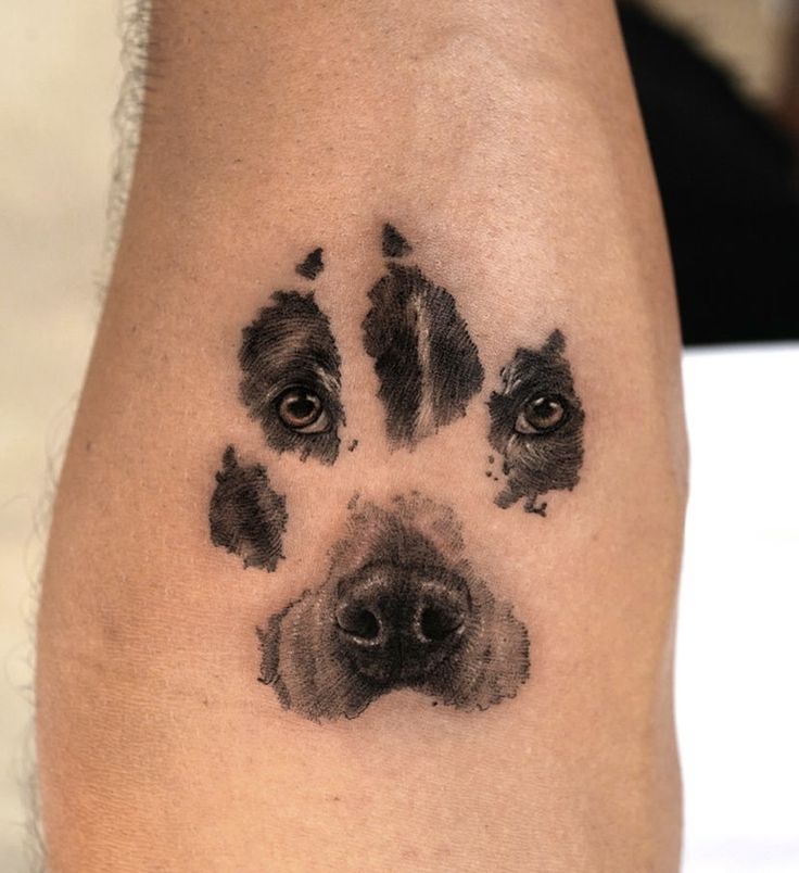 a dog's paw is shown with black ink on the left side of his arm