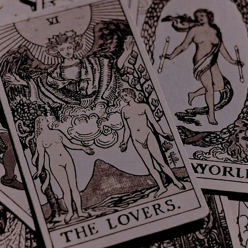 four different tarot cards are shown in close up, with one being an angel and the other is a demon