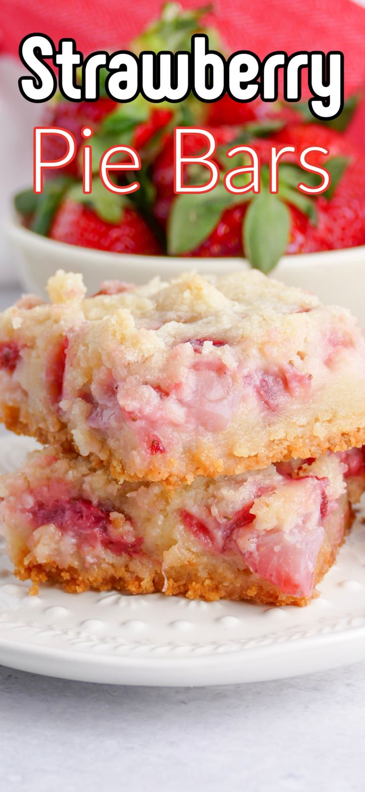 two pieces of strawberry pie bar on a plate with strawberries in the background and text overlay