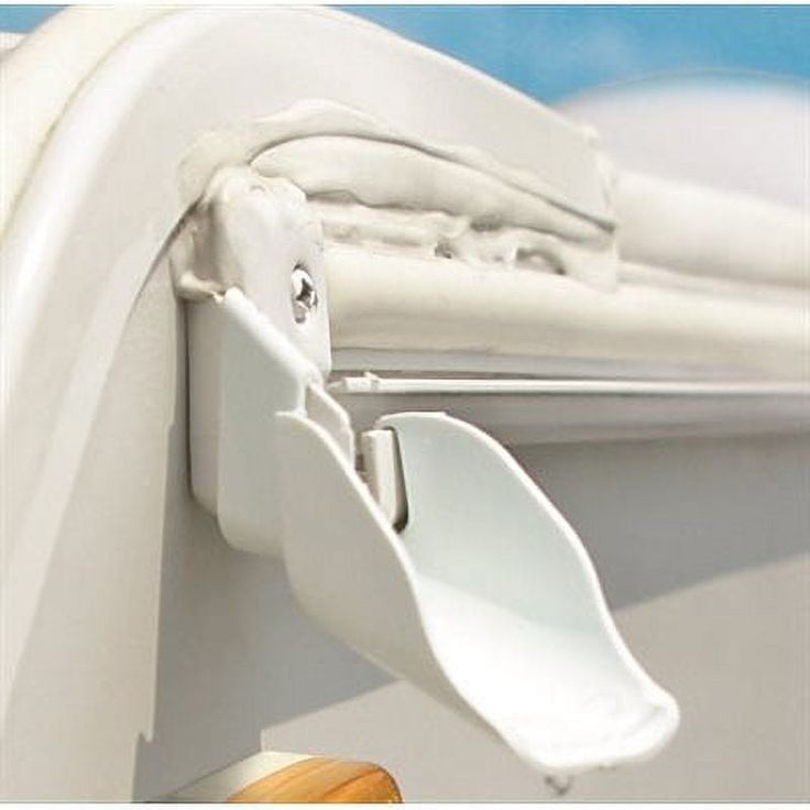 a close up view of a white door handle on a closed window with blue sky in the background