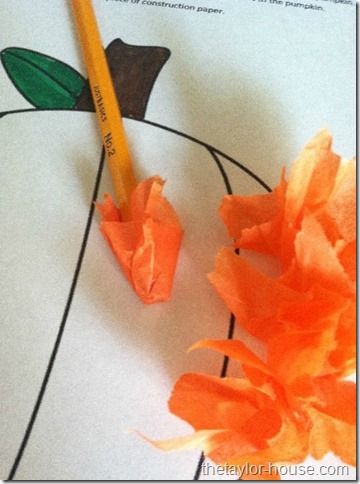 an orange flower next to a pencil on a piece of paper with writing underneath it