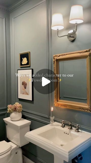 a bathroom with blue walls and gold framed pictures on the wall, along with a white toilet and sink