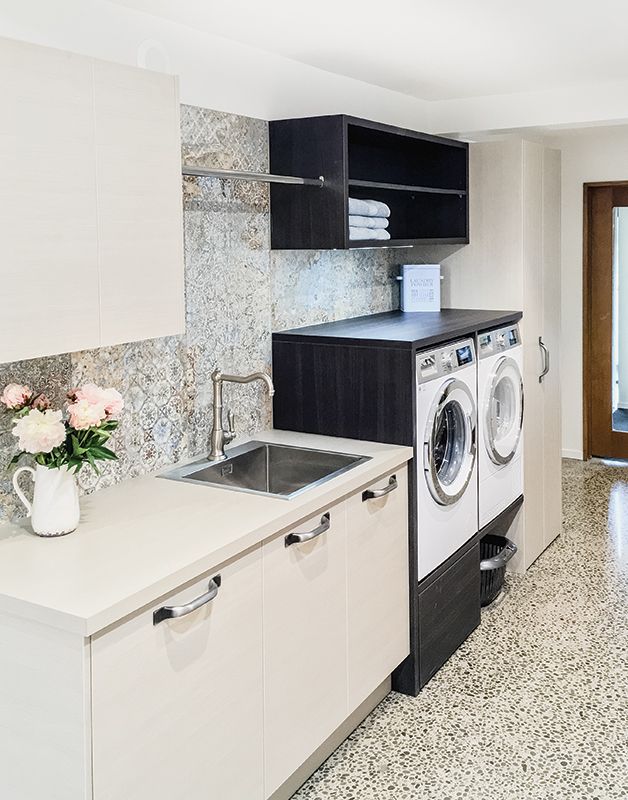 a washer and dryer in a room with tile flooring on the walls