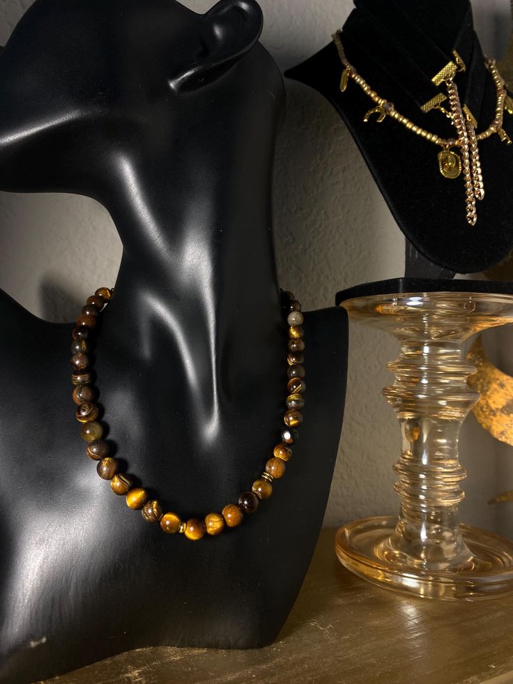 A lot of style and a lot more meaningful. This one is for him or her. ✨ Made with high quality Tigers Eye gemstones, with a few added gold accent beads.  Tigers Eye is a beautiful and powerful stone and symbol of focus and clarity. It's known to help enhance self confidence and self awareness, which can help strengthen Will power and integrity.  One necklace per order Comes in two Sizes Short: Adjustable from 14in to 16in Long: 24' Gold Spiritual Crystal Necklace With Polished Beads, Amber Necklaces With 8mm Beads For Gift, Spiritual Amber Polished Beads Jewelry, Amber Bead Necklace 8mm As Gift, Amber Necklace With 8mm Beads For Gift, Brown Round Jewelry For Healing, Spiritual Amber Crystal Necklaces With Round Beads, Spiritual Brown Gemstone Jewelry, Elegant Brown Jewelry For Meditation