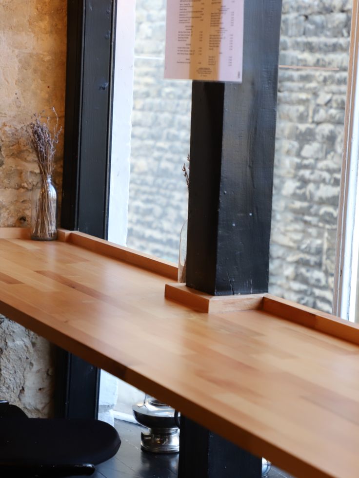 a wooden table sitting in front of a window