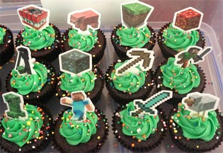 cupcakes with green frosting and decorations in a plastic container on a table