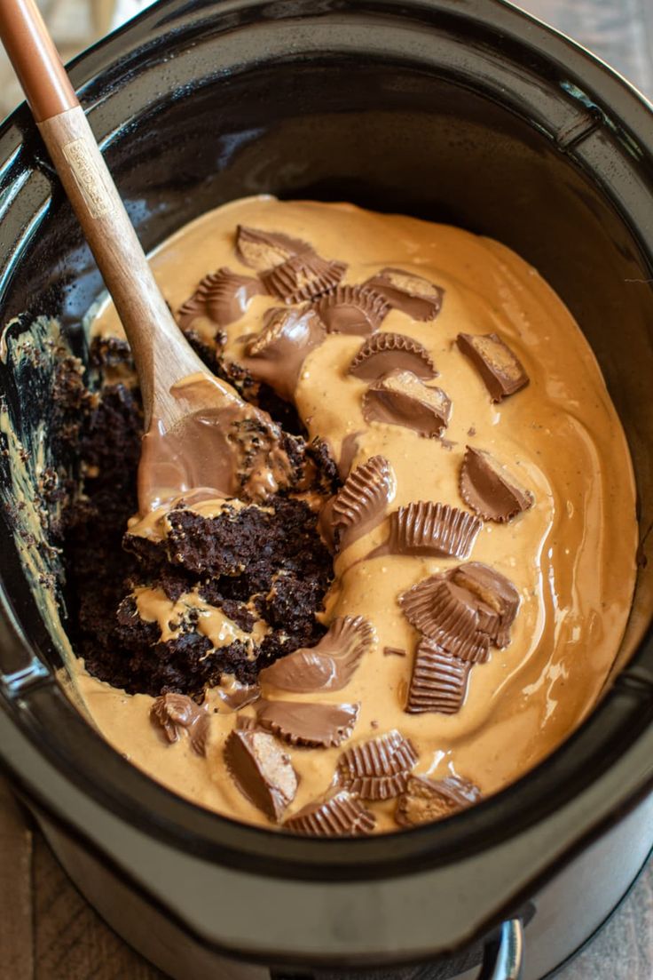 a chocolate cake in a crock pot with a wooden spoon sticking out of it