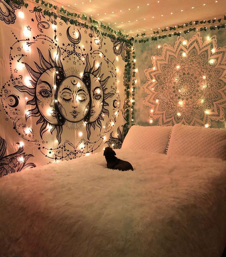 a cat sitting on top of a bed in a room decorated with lights and decorations