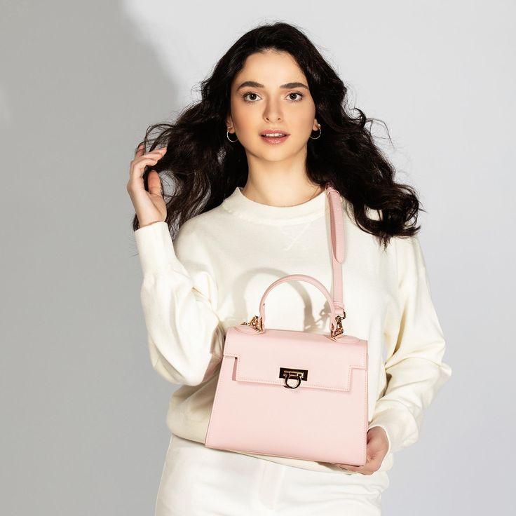 Feminine Pink Top Handle Bag -Chic & Versatile. Introducing our latest collection addition, Layla Bag in Pink. Lean into the femininity of a soft pink bag, perfect for spring and summer. This new-season Enjoy the versatility of Layla Bag with its adjustable strap, allowing you to wear it comfortably as a crossbody or shoulder bag, depending on your style preference. Bag Specifications Material: Vegan leather Interior: Luxurious suede lining Handles: Single handle, Removable shoulder strap Hardware: Golden-tone metal flap Pockets: One inner zipped pocket Closure: Front flap closure Size and Fit- Height: 20 cms / 7.9 In Handle Height: 10 cm / 3.9 In Width at bottom: 26 cm / 10.2 In Depth at bottom: 11 cm / 4.3 In Adjustable strap length: 55-60 cms / 21.7-23.6 ins Feminine Rectangular Bag For On-the-go, Pink Top Handle Bags For Shopping, Chic Satchel Flap Bag With Removable Pouch, Evening Chic Tote Flap Bag, Luxury Pink Shoulder Bag With Top Carry Handle, Chic Evening Tote Flap Bag, Chic Tote Flap Bag With Detachable Handle, Feminine Shoulder Bag With Removable Pouch For On-the-go, Luxury Spring Bags For On-the-go