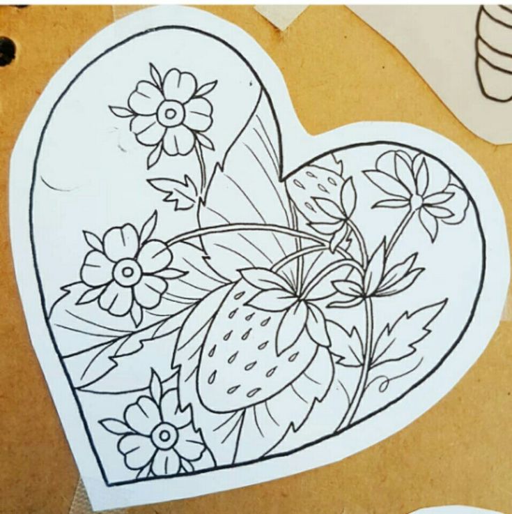 a heart shaped paper cut out with flowers and strawberries on it, surrounded by other crafting supplies