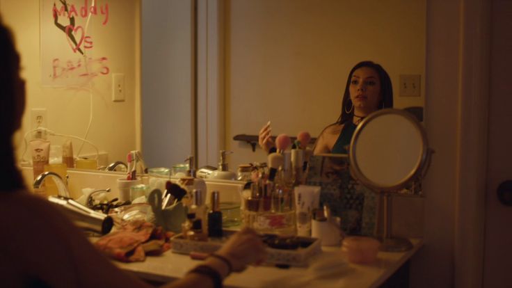 a woman standing in front of a bathroom mirror