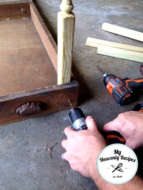 a man is using a drill to repair a piece of wood that has been placed on the ground