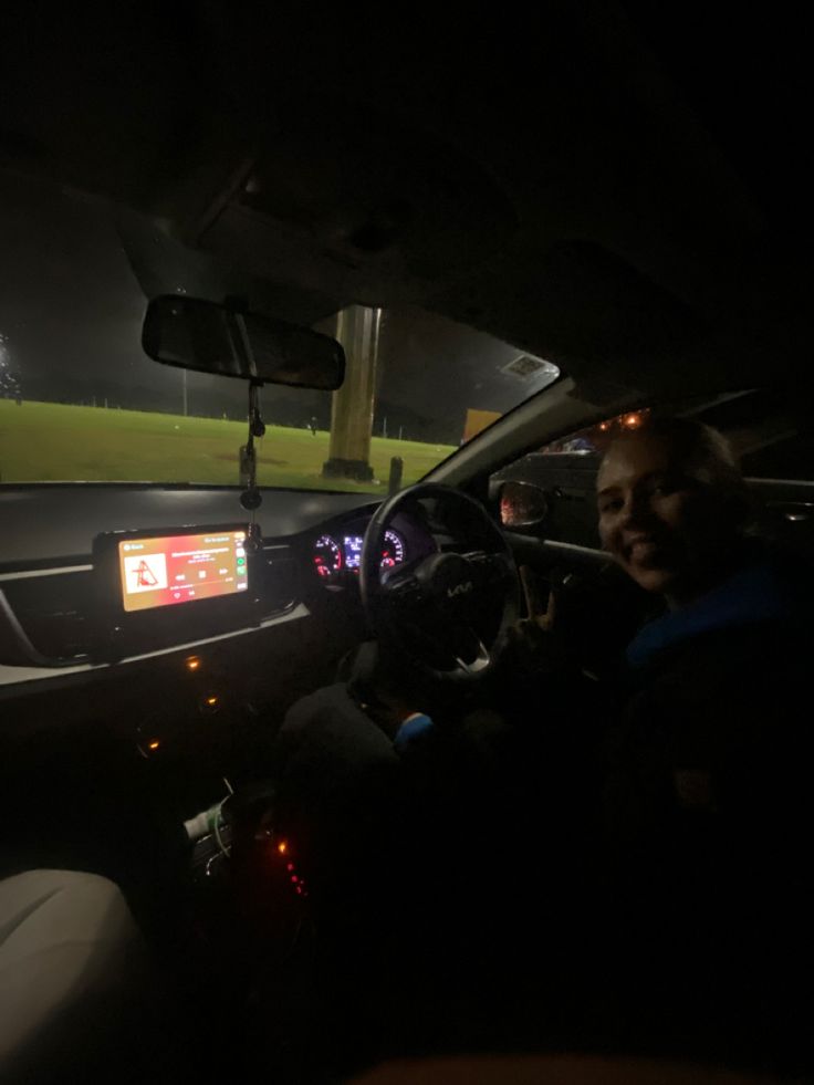 the interior of a car at night with people sitting in it and one person driving