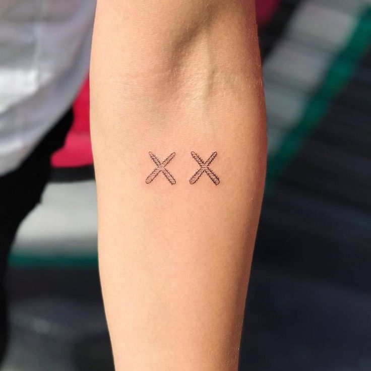 two crossed crosses tattoo on the arm